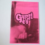 Black and pink "Gypse Eyes" cover. Photograph of a person making 'the middle finger' gesture. Decorative font title in the centre of the page..