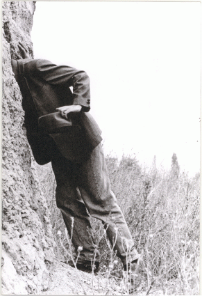 Black and white "Not secret" zine cover. Photograph of a man holding a hat with his head in some rocks.
