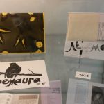 Colour photograph of "Athemaura" zine material in a glass display cabinet.