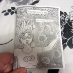 Hand holding zine "(meta)paradox #5 the neuroqueer issue". Cover shows title and drawing of person seemingly floating among bubbles.